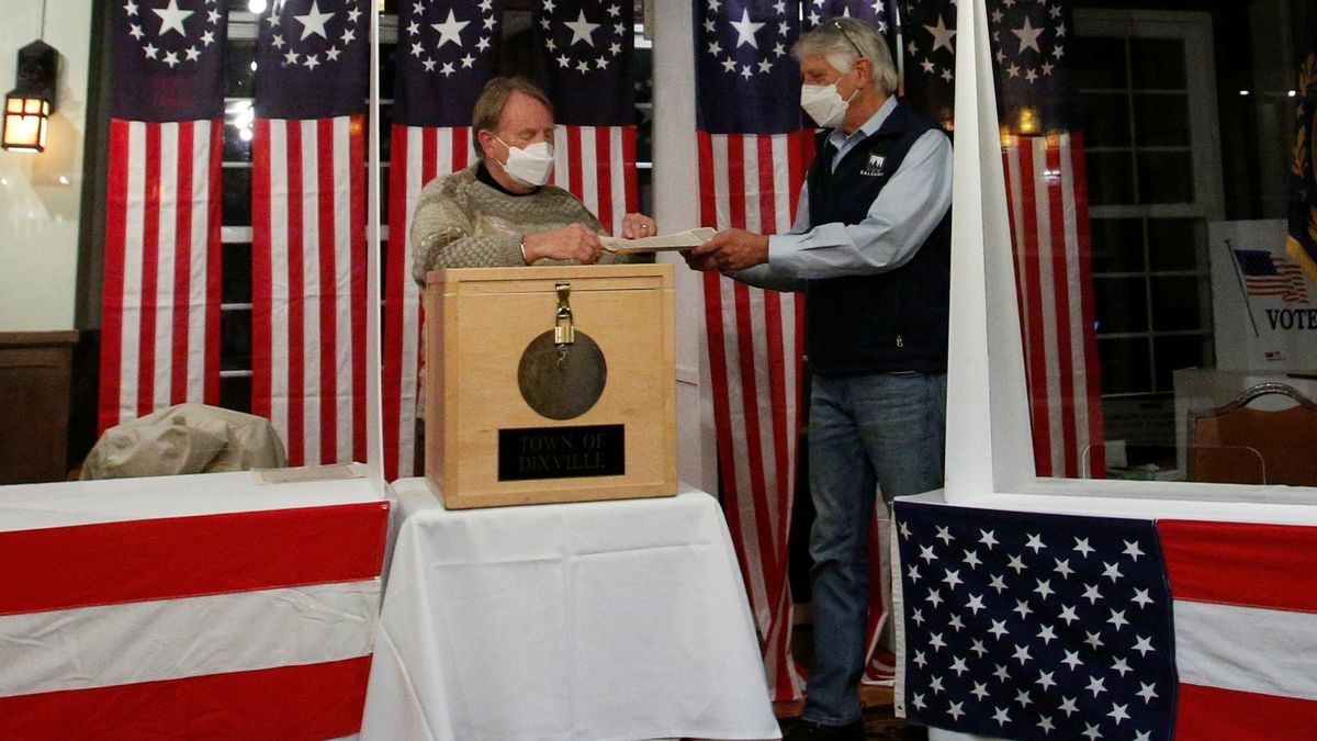 0_Les-Otten-hands-his-ballot-to-Tom-Tillotson-to-be-put-in-a-box-for-the-US-presidential-election-at