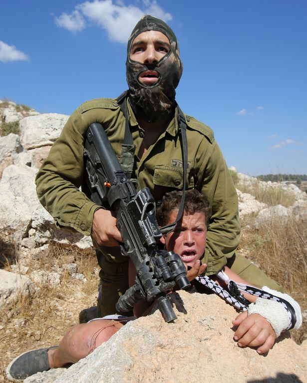 An-armed-Israeli-soldier-controls-a-Palestinian-boy-during-clashes-between-Israeli-security-forces-and-Palestinian