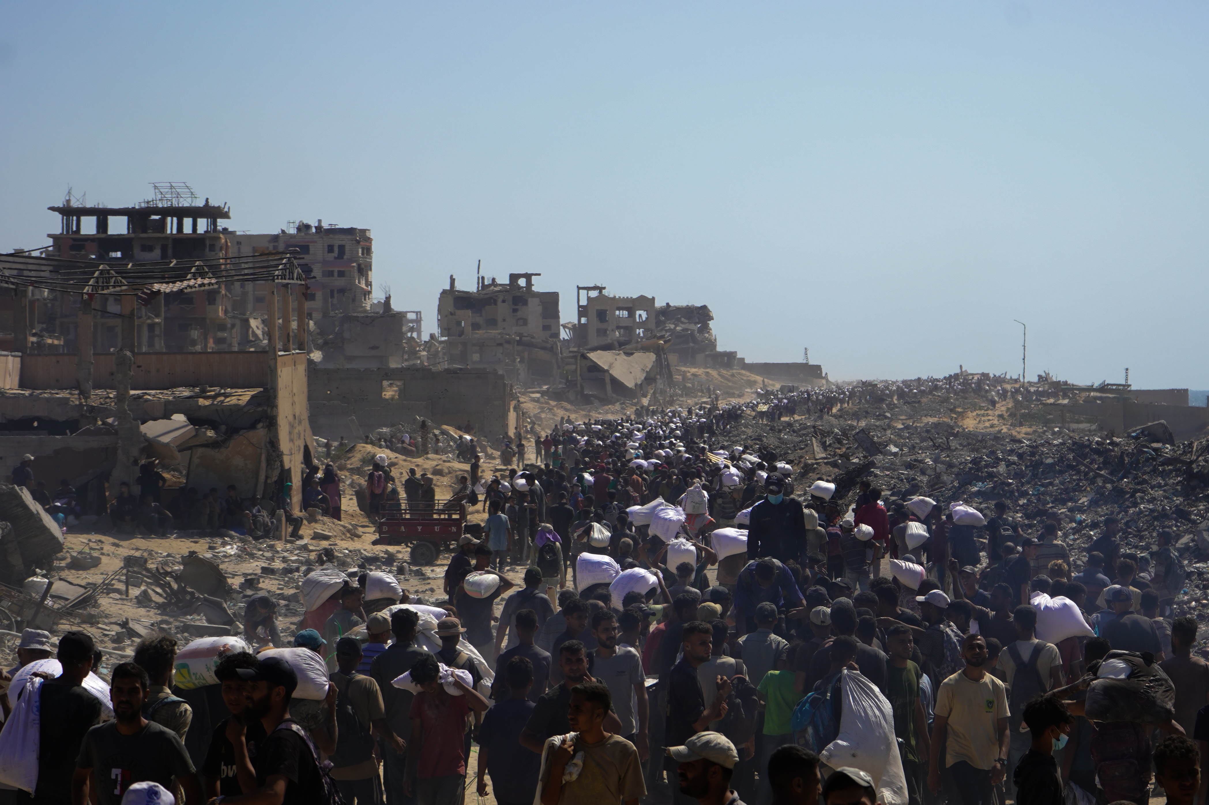 AA-20250801-38724944-38724912-ISRAILIN_ACLIGA_MAHKUM_ETTIGI_GAZZELILER_KISITLI_MIKTARDAKI_UNA_ULASMAK_UZERE_ZIKIMDEKI_YARDIM_DAGITIM_NOKTASINA_GITTI