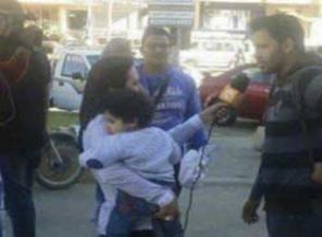 Kucağında oğlunu taşıyarak insanlarla röportaj yaptı
